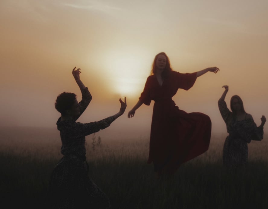 A Group of Women Dancing on Grass Field